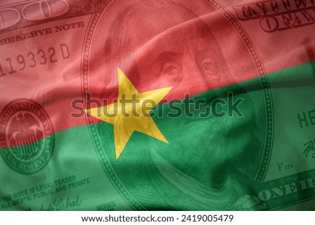 waving colorful national flag of burkina faso on a american dollar money background. finance concept.