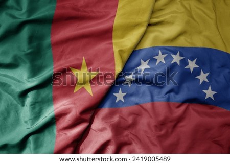 big waving national colorful flag of venezuela and national flag of cameroon . macro