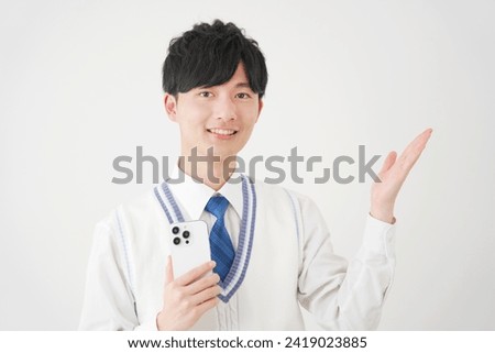 Asian high school boy with the smartphone pointing side in white background