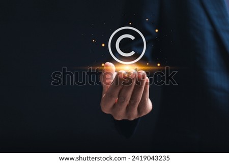 Copyright or patent concept, copyleft trademark license. Businessman holding virtual copyright symbol for author rights and patented intellectual property. 