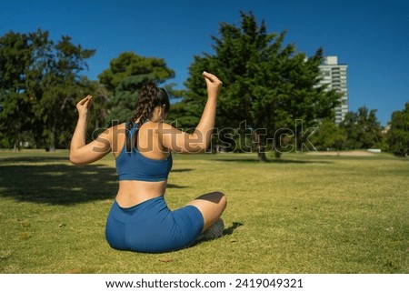 A woman practicing yoga, focusing on breathing. Outdoor exercise.