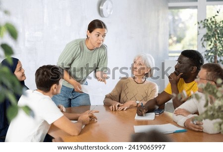 Young female manager holds round table meetings for employees of different nationalities Royalty-Free Stock Photo #2419065997
