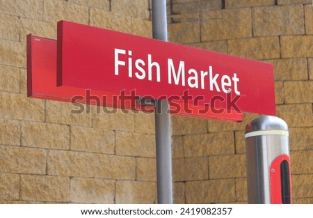 Orange Fish Market signage on a pole at the light rail station