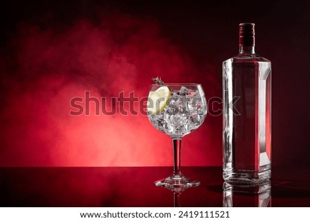Gin tonic on red background with smoke with copyspace.