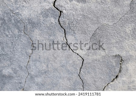 The wall of an old building with many winding, deep cracks. Copy space. Selective focus. Royalty-Free Stock Photo #2419111781