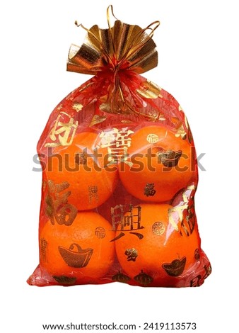 Oranges in a Chinese cloth bag isolated on white background. Oranges are auspicious fruits according to Chinese beliefs because their skin color is like gold. And in Chinese it also means happiness.