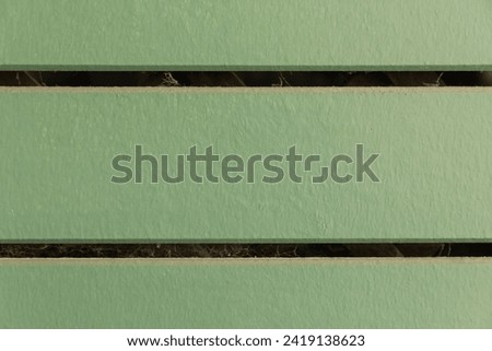 Details of the background of the wooden wall painted green, natural light under the eaves in the afternoon zooming in close-up is a beautiful background with the green tone that is popular right now.