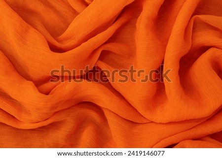 photographing orange drapery with folded tones can create warm and vibrant visual impact utilize natural light to enhance the richness of the orange tones and highlight the intricates folds of  fabric Royalty-Free Stock Photo #2419146077