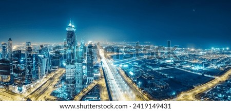 Spectacular urban skyline with colourful city illuminations. Aerial view on highways and skyscrapers of Dubai, United Arab Emirates. Royalty-Free Stock Photo #2419149431