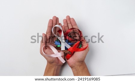 man holding colorful ribbons in his hands. Support World Cancer Day