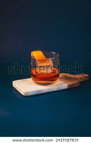 Old Fashioned Whiskey Cocktail in Blue Background 