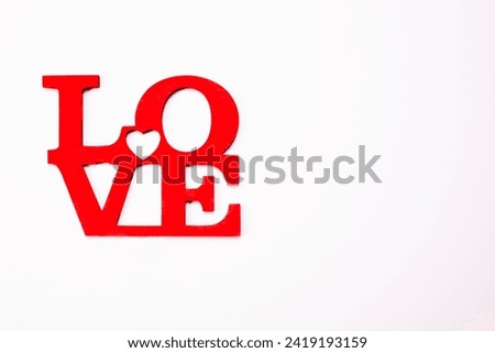The word love in wooden red letters on white background. Valentine's day, Mother's Day, March 8 holiday card concept