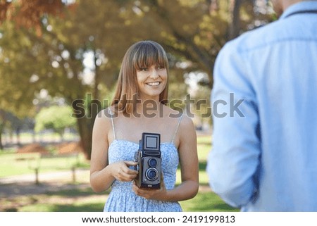 Couple, park or happy woman with vintage camera for outdoor photography, photo memory or tourism. Retro equipment, creative photoshoot or photographer shooting boyfriend for garden picture in nature