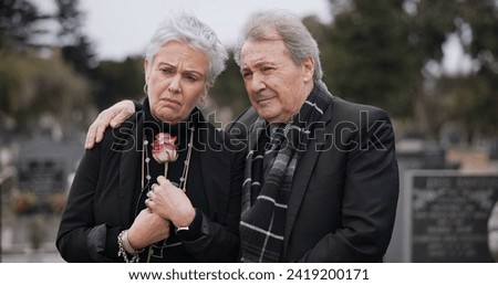 Funeral, graveyard and sad senior couple hug for comfort, empathy and support at memorial service. Depression, grief and man and woman embrace with flower for goodbye, mourning and burial for death Royalty-Free Stock Photo #2419200171
