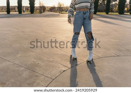 Woman in Quad Skates Posing at Sunset in Skate Park. Lower body shot of a woman posing with quad skates at sunset.