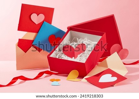 Colorful handmade cards decorated with a gift box in red color. Paper cut in heart-shaped are displayed with a red ribbon. International Women's Day is now celebrated in over 100 countries