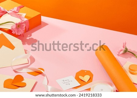 Pink surface featured many items for Women’s Day concept such as cards, gift box, paper hearts, a roll of paper and macaroon. Vacant space in the middle for product or goods presentation