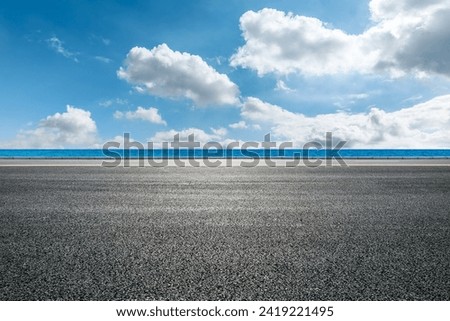 Asphalt road and blue lake water nature landscape under blue sky Royalty-Free Stock Photo #2419221495