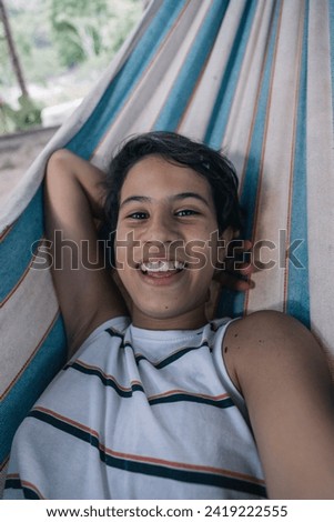Teenage girl stretched out on a hammock taking a selfie