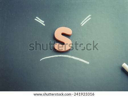 Wooden S character on black board