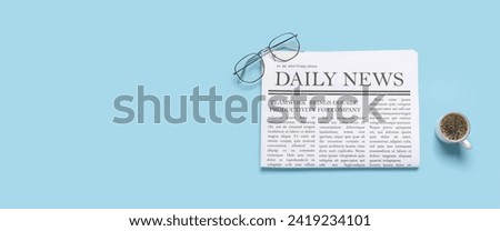 Daily newspaper with cup of coffee and eyeglasses on light blue background with space for text