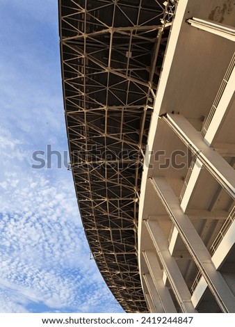 Architectural photo of part of a football stadium with blue sky in the background.