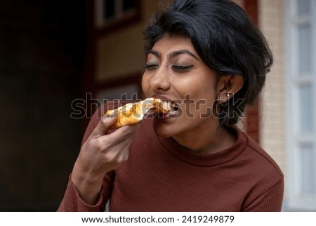 multiracial woman, eating fast food, outdoor food eating woman, enjoying, eating unhealthy fast food, high cholesterol carb food, teenage addict, obesity, enjoying her Pizza