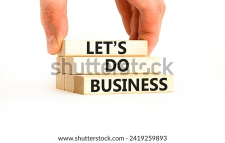 let is do business symbol. Concept words let is do business on beautiful wooden blocks. Beautiful white table white background. Businessman hand. let is do business concept. Copy space.