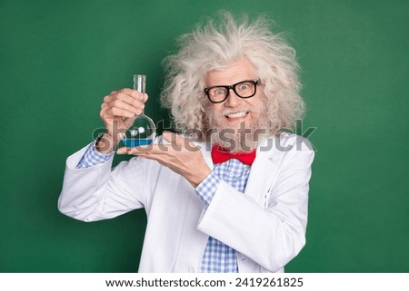 Photo of happy smiling funky funny mad scientist hold glass with liquid crazy experiment isolated on green color background Royalty-Free Stock Photo #2419261825