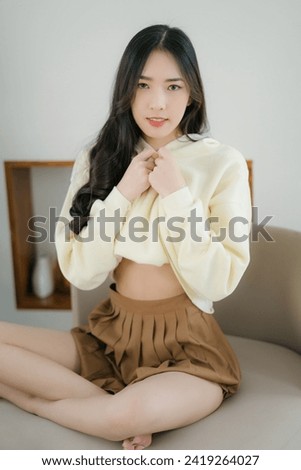 Cute Asian girl in yellow pastel hoodies