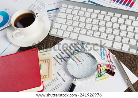 Close up of keyboard documents and coffee on office table