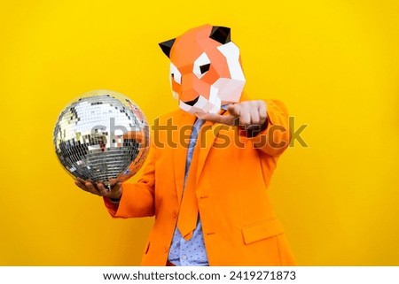 Cool man wearing 3d origami paper mask with stylish colorful clothing - Creative concept for advertising, animal head mask doing funny things on isolated colored background with copy-space