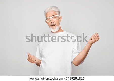 Portrait of smiling face gray-haired man clenching fists and rejoicing, celebrating victory isolated on white studio background, advertising banner
