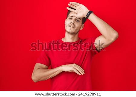 Young hispanic man standing over red background touching forehead for illness and fever, flu and cold, virus sick  Royalty-Free Stock Photo #2419298911