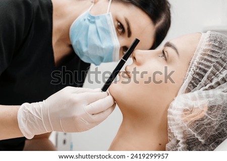 Beautiful young woman getting cosmetology treatment facial skin injection by doctor beautician. Perfect facial proportions after injections. Face correction Royalty-Free Stock Photo #2419299957