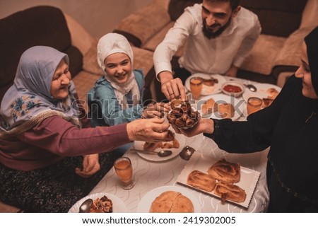 Happy Muslim family having iftar dinner during Ramadan dining table at home. High quality photo Royalty-Free Stock Photo #2419302005