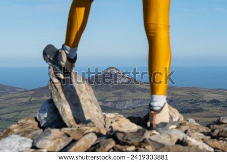 Legs of a mountaineer woman in a mountain top, in the background the great sugarloaf mountain, Wicklow Ireland
