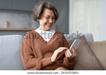 Closeup cropped front view photo of senior old elderly caucasian woman grandmother using smart phone cellphone for e-banking e-commerce, surfing social media online at home