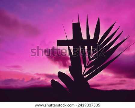 Silhouette of hand holding palm leaves and cross with purple sky background. Lent, Holy Week, Palm Sunday and Good Friday Concept. Royalty-Free Stock Photo #2419337535