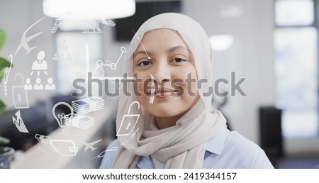 Image of globe with icons data processing over biracial businesswoman in office. Global networks, business, finances, computing and data processing concept digitally generated image.
