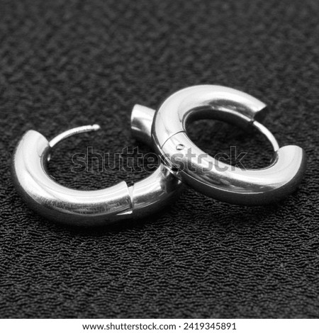 Fake hard earring. White silver ear ring. Imitation jewelry. Accessory for rockers, rap, hip-hop, bikers, emo. Creation of a scenic view. Pirate style.