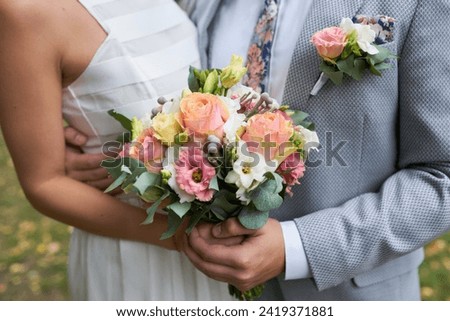 Tender hands cradle a bridal bouquet, a symbol of love and beauty.