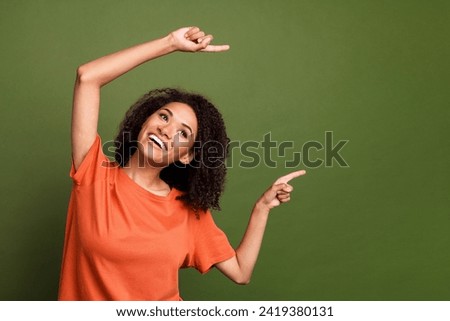 Photo portrait of attractive young woman point look excited empty space wear trendy orange clothes isolated on khaki color background