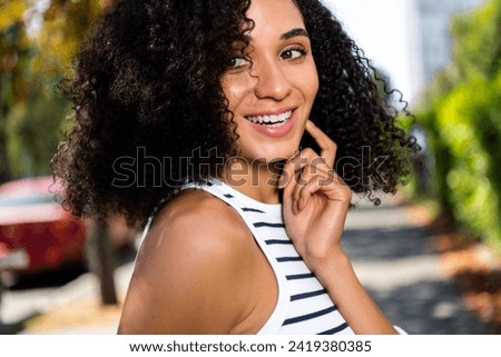 Photo of positive adorable cute cheerful girl in town park enjoying sunny weather pastime good mood cityscape