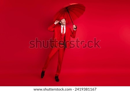 Full length photo of elegant young male dancing musical performance umbrella wear trendy classic garment isolated on red color background Royalty-Free Stock Photo #2419381167
