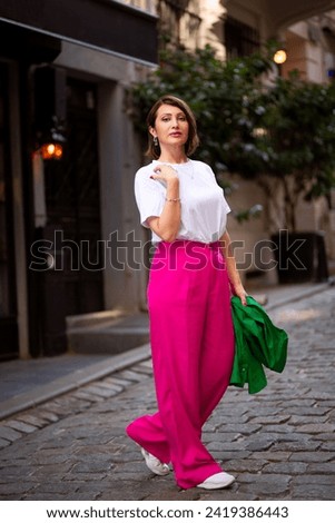 Successful woman business lady psychology coach posing in the city. Pretty middle-aged woman business executive taking photo