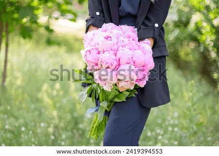 Big pink piony bouquet in woman’s hand. Happy woman’s day. Pink flowers