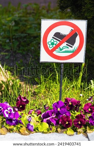 sign prohibiting entry onto the lawn with flowers. prohibition to step on the flowerbed, vertical photo
