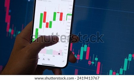 Crypto trader investor broker holding finger using cell phone app executing financial stock trade market at the night. Dark theme, close up shot. Royalty-Free Stock Photo #2419413767