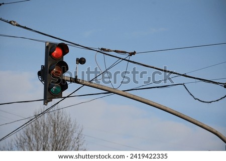 Traffic light with red yellow green above the road, many wires